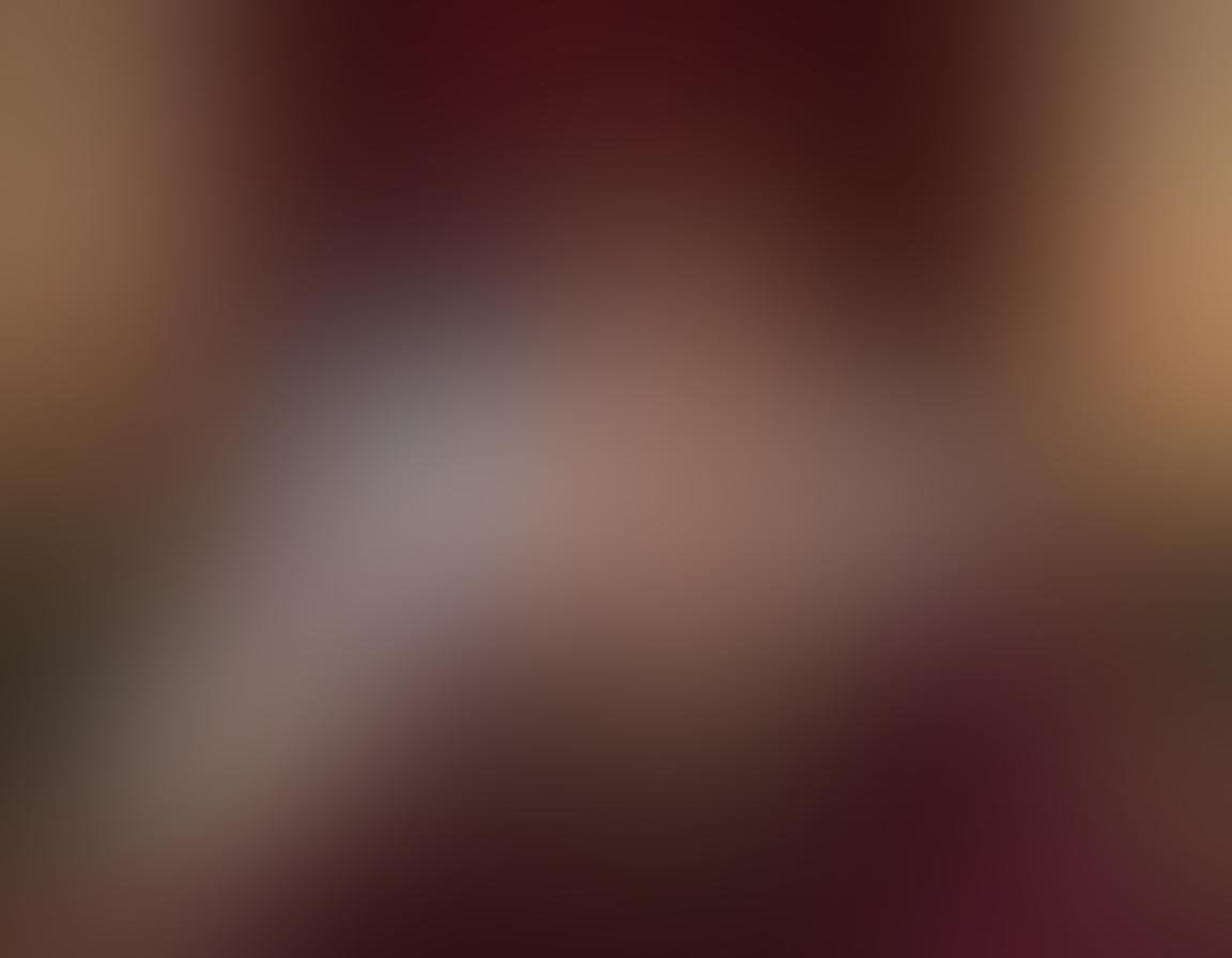 A confident, curvy figure dressed in elegant, flowing lingerie, posed in an inviting manner against a softly lit boudoir backdrop. The scene exudes sensuality with plush velvet textures, delicate lace accents, and soft candlelight reflections. Include playful elements like silk sheets and rose petals scattered around, creating an atmosphere of indulgence and allure. The color palette should feature rich, warm tones to evoke passion and comfort. super-realistic. vibrant colors. intimate setting.